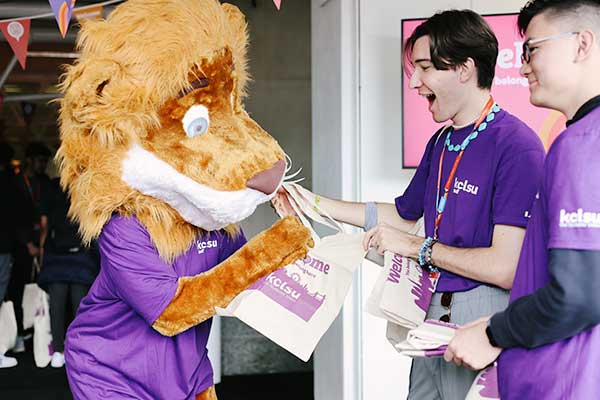 The KCLSU lion mascot handing out welcome fair totes