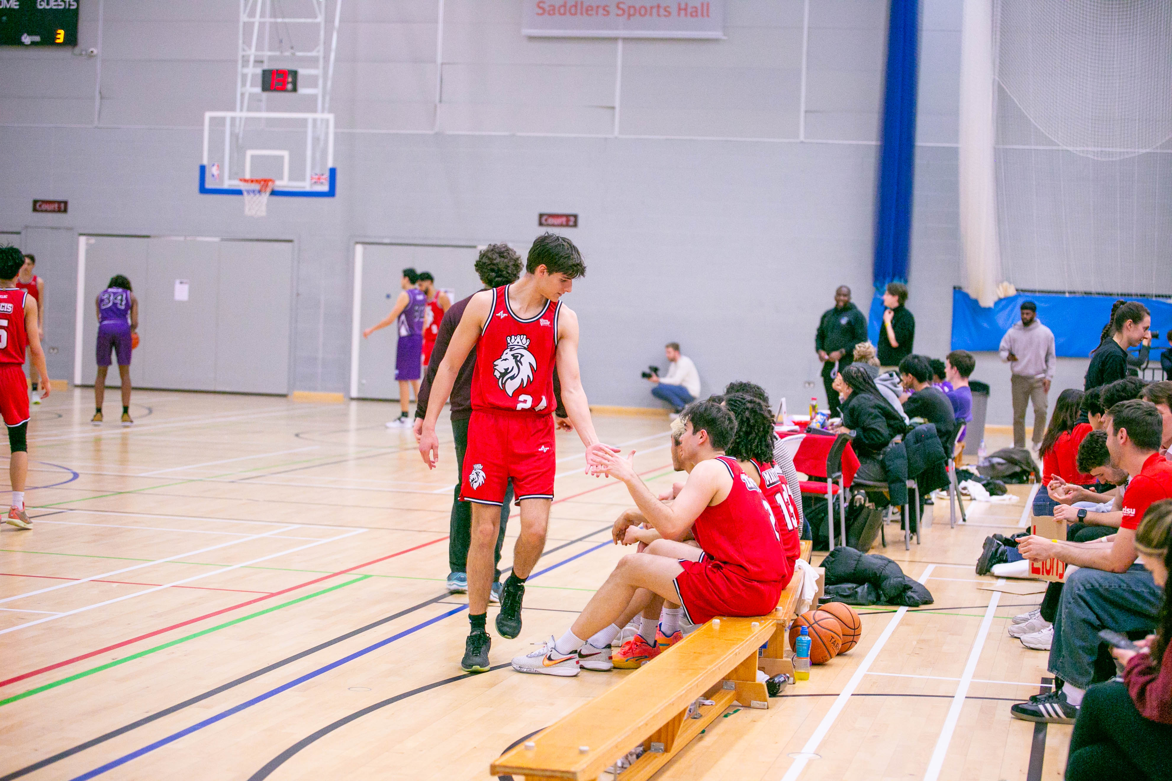 Basketball team high fiving.