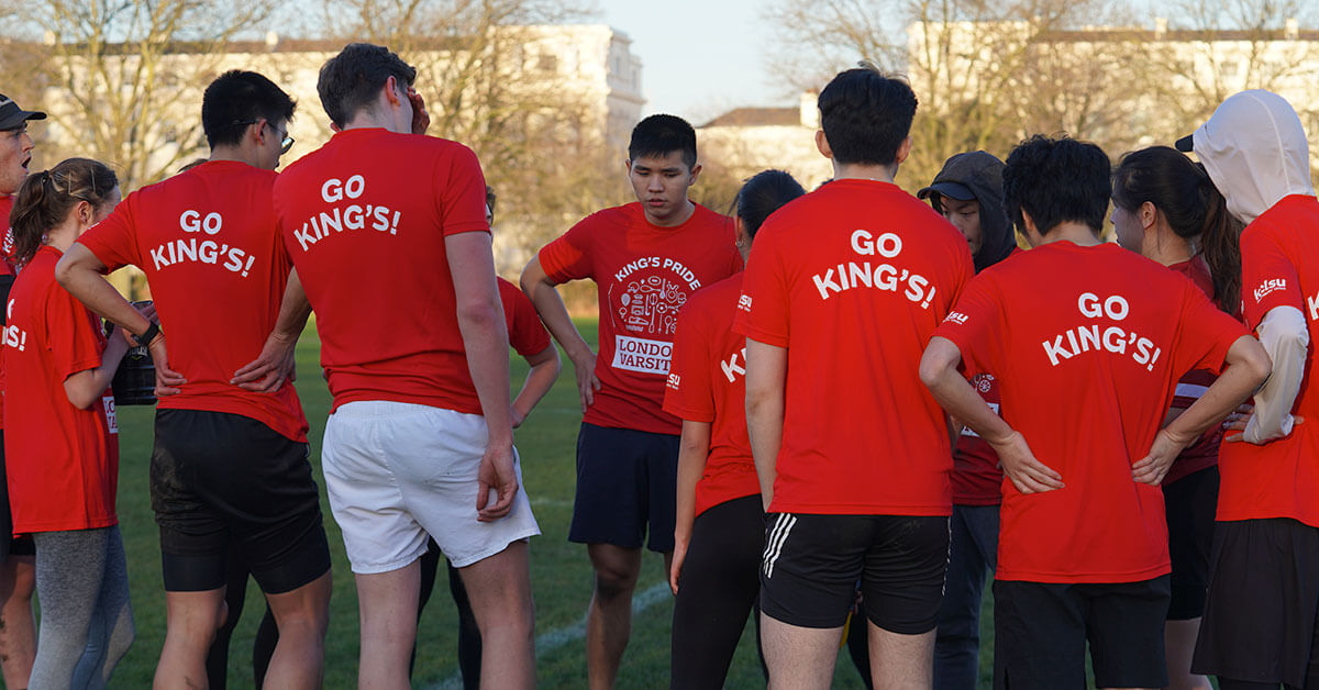 KCL players wearing red t-shirts that say 'Go King's!' and stood in a huddle