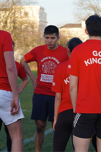 KCL players wearing red t-shirts that say 'Go King's!' and stood in a huddle