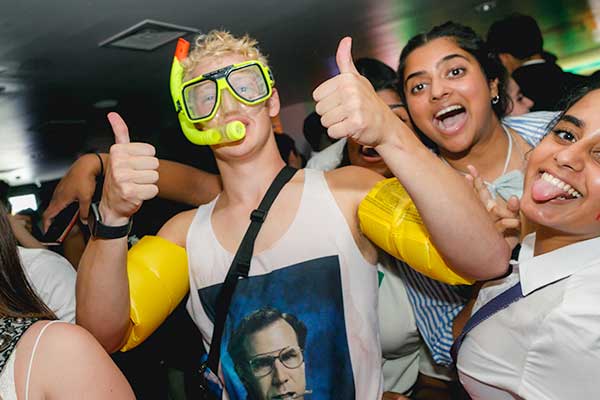 A student at a themed club night wearing a green snorkle mask